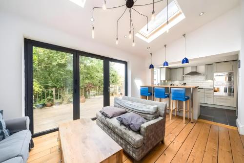 a living room with a couch and a kitchen at EEJs Luxe 5 Bed Home - Greenwich in London