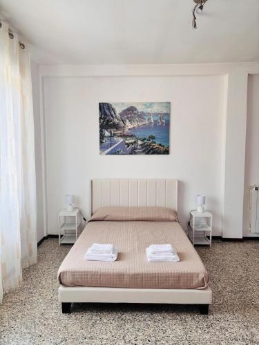a bedroom with a bed with two tables and a painting on the wall at Maison Du Soleil in Somma Lombardo