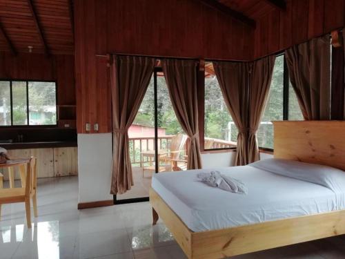 a bedroom with a bed and some windows at Kraken Haus Reef & Reel Lodge in Drake