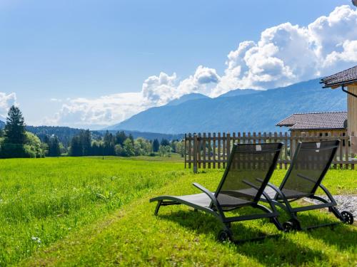 two chairs sitting in a field with mountains in the background at Obermöschach 9B in Obermöschach