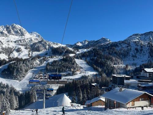 a ski resort with people on a ski lift in the snow at Obermöschach 10A in Obermöschach