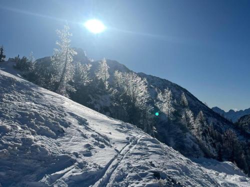 a snow covered hill with the sun in the background at Obermöschach 10A in Obermöschach