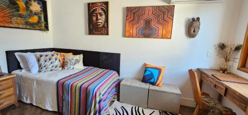 a bedroom with a bed and a chair in it at Pousada Chalé Poder das Pedras in Sao Paulo