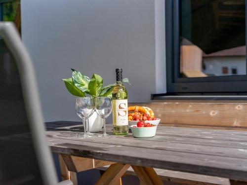 a bottle of wine and glasses on a wooden table at Obermöschach 10A in Obermöschach