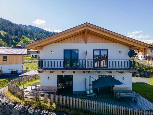 a house with a balcony and an umbrella at Obermöschach 10B in Obermöschach