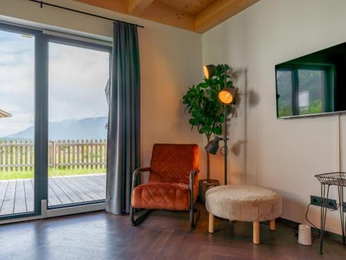 a living room with a chair and a sliding glass door at Obermöschach 10B in Obermöschach