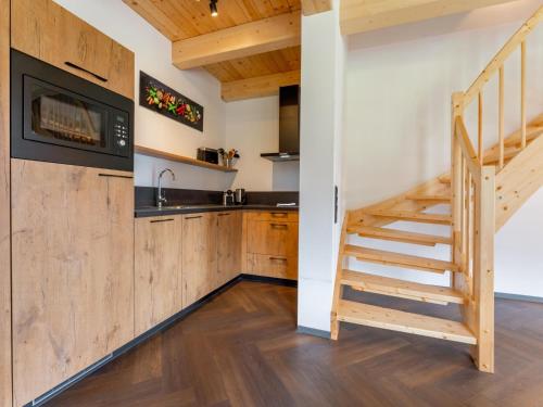 a staircase leading up to a kitchen with wooden floors at Obermöschach 10 in Obermöschach
