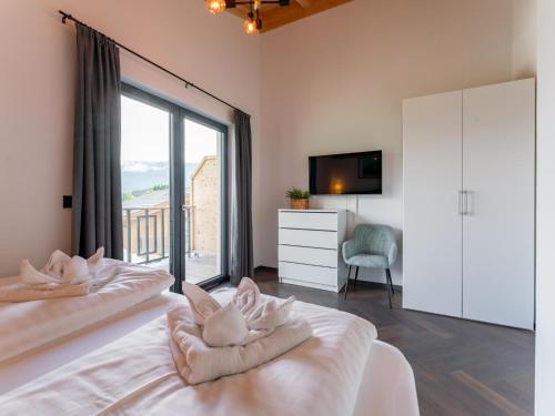 a bedroom with two beds and a large window at Obermöschach 10 in Obermöschach