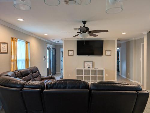- un salon avec un canapé en cuir et une télévision à écran plat dans l'établissement Reel Fun Family Retreat, à Ingleside