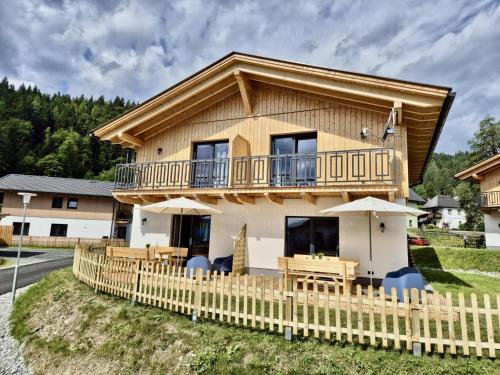 a log home with a deck and a fence at Obermöschach 6A in Obermöschach