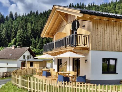 a house with a deck with a table and chairs at Obermöschach 6A in Obermöschach