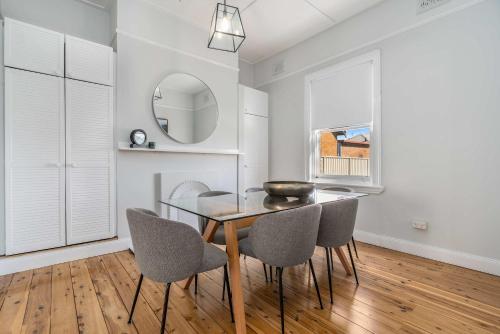 a dining room with a glass table and chairs at Incredible Location 2 Bed CBD Dream in Orange