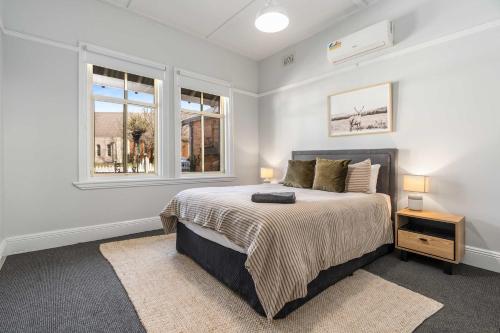a bedroom with a bed and two windows at Incredible Location 2 Bed CBD Dream in Orange