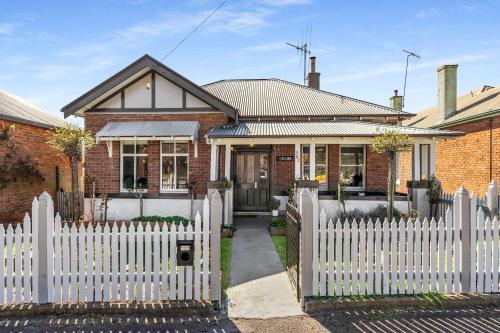 a white picket fence in front of a house at Incredible Location 2 Bed CBD Dream in Orange