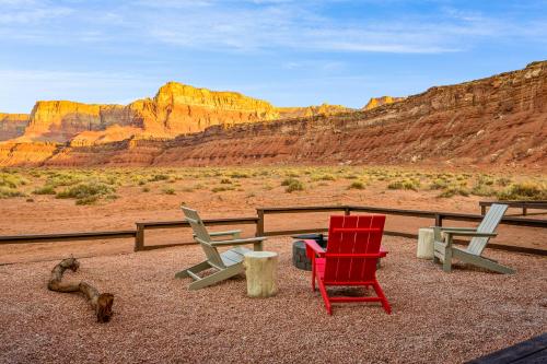 three chairs and a table in the desert at Marble Canyon Lodge in Marble Canyon
