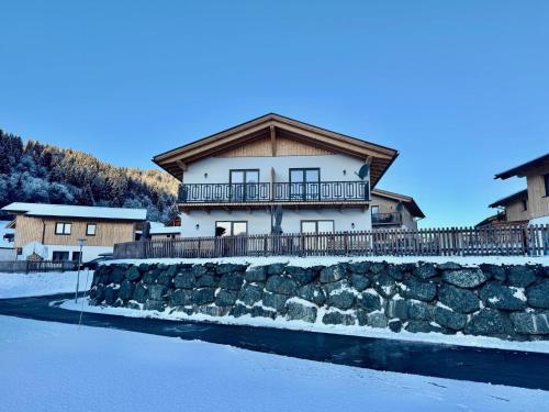 a house on top of a stone wall next to a lake at Obermöschach 10 in Obermöschach