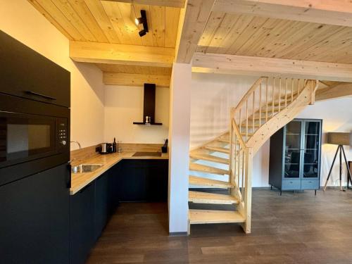 a kitchen with a spiral staircase in a house at Obermöschach 6A in Obermöschach