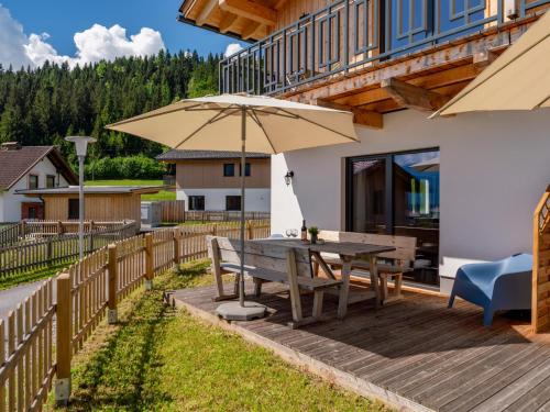 a wooden deck with a table and an umbrella at Obermöschach 6A in Obermöschach