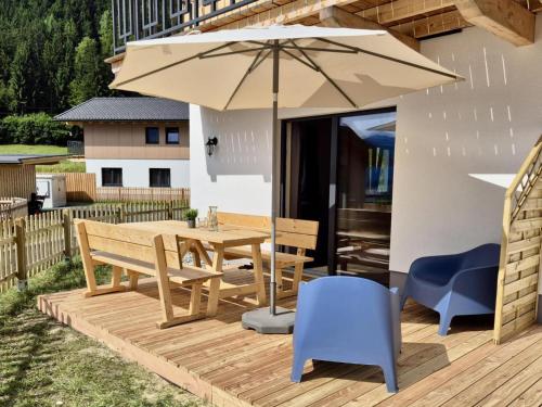 a wooden deck with a table and an umbrella at Obermöschach 6A in Obermöschach