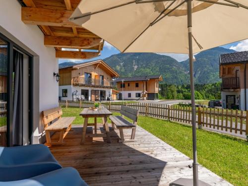 a wooden deck with a table and an umbrella at Obermöschach 6B in Obermöschach