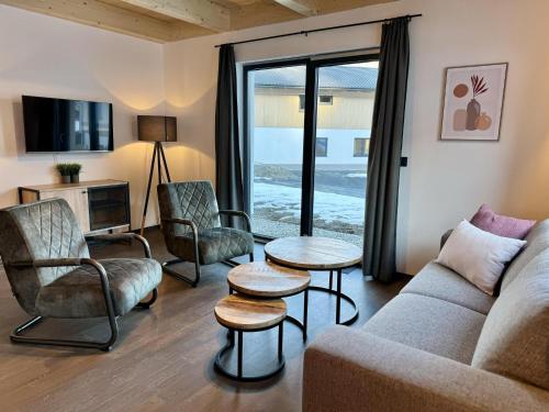 a living room with a couch and chairs and a tv at Obermöschach 6 in Obermöschach