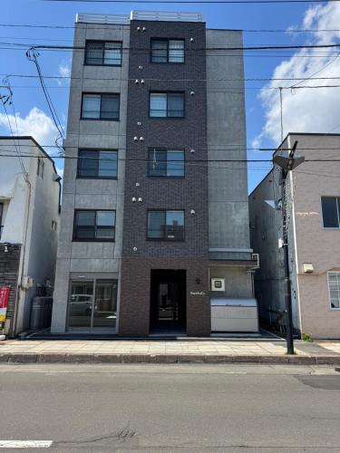 a tall building on the corner of a street at Stisfy サティスファイ in Chitose