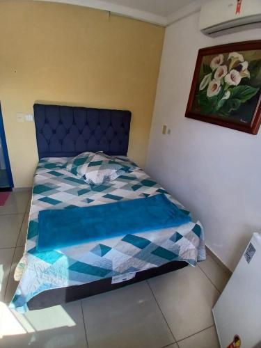 a bedroom with a bed with a blue and white comforter at Vip Girassol in Cuiabá