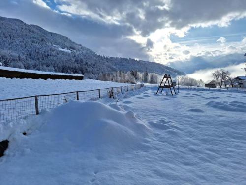 a snow covered field with a fence and a snow covered ground at Jukbichl 2 in Laas