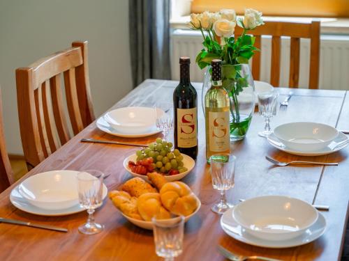 a table with two bottles of wine and a bowl of fruit at Jukbichl 2 in Laas