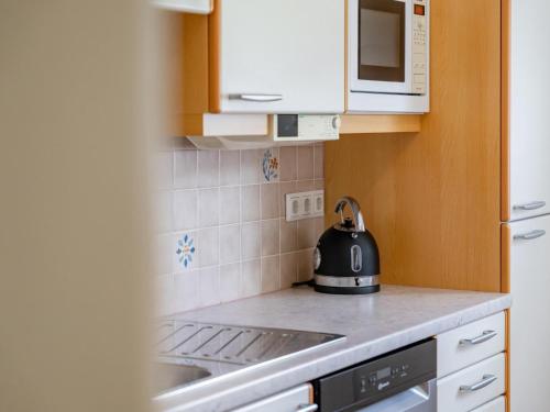 a black tea kettle sitting on top of a stove in a kitchen at Jukbichl 2 in Laas