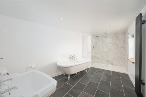 a white bathroom with a tub and a sink at Soundwaves, Seatown, Gardenstown in Gardenstown