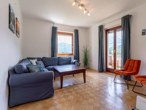 a living room with a blue couch and a table at Jukbichl in Laas