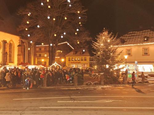 a crowd of people standing around a christmas market at Jukbichl in Laas