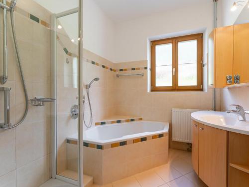 a bathroom with a shower and a tub and a sink at Jukbichl in Laas