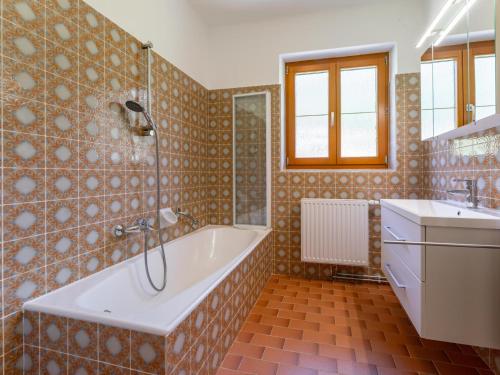 a large bathroom with a tub and a sink at Jukbichl in Laas