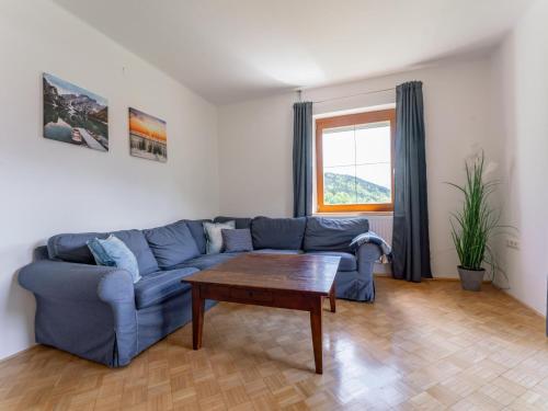 a living room with a blue couch and a table at Jukbichl in Laas