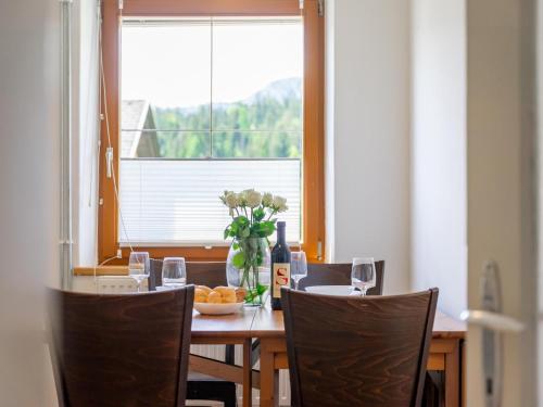 a table with a vase of flowers and a bottle of wine at Jukbichl in Laas