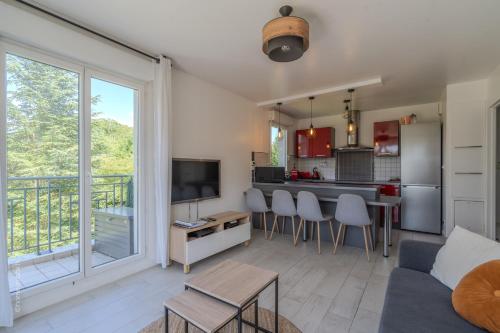 un salon avec un canapé et une télévision et une cuisine dans l'établissement Appartement central 6 personnes à 10 minutes de Disneyland, à Montévrain