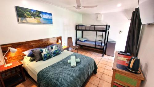 a bedroom with a bed with a teddy bear on it at Rainforest Motel in Mission Beach