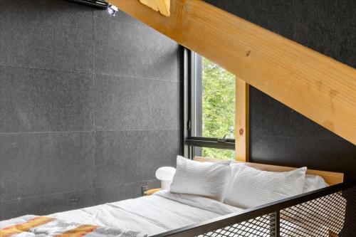 Un dormitorio con una litera y una ventana. en La Cabine Hygge, en Saint Roch de Mekinac