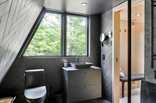 Un baño con lavabo y ventana. en La Cabine Hygge, en Saint Roch de Mekinac