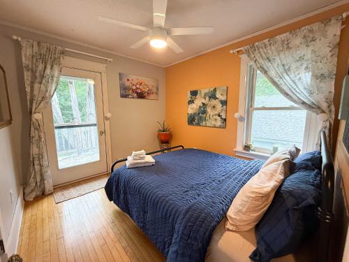 a bedroom with a blue bed and a window at Historic North Fargo Charm near NDSU in Fargo