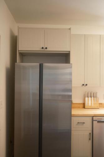 a stainless steel refrigerator in a kitchen with white cabinets at Modern Character Downtown Fargo in Fargo