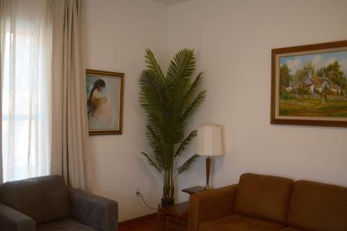 a living room with a couch and a palm tree at Modern Character Downtown Fargo in Fargo