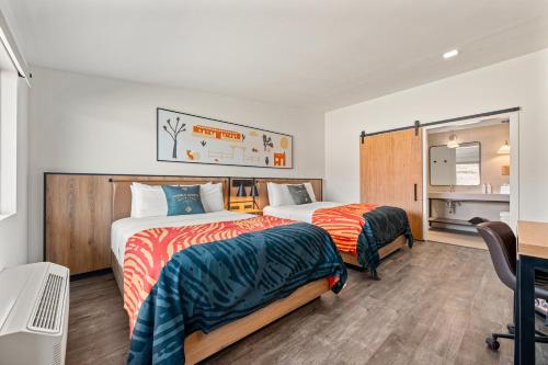a hotel room with two beds and a desk at Marble Canyon Lodge in Marble Canyon