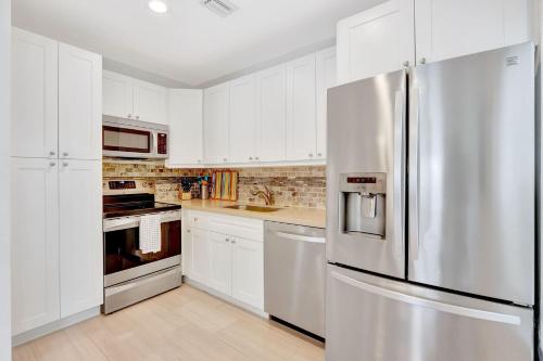 a kitchen with white cabinets and a stainless steel refrigerator at 320-1 Las Olas Boulevard in Fort Lauderdale