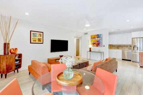 a living room with a glass table and orange chairs at 320-1 Las Olas Boulevard in Fort Lauderdale