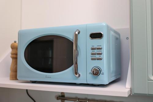 a blue microwave sitting on top of a shelf at Studio Vecini cu Marea in Costinesti
