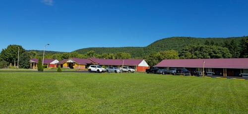 a group of buildings with cars parked in a field at Mark Twain Motor Inn in Elmira
