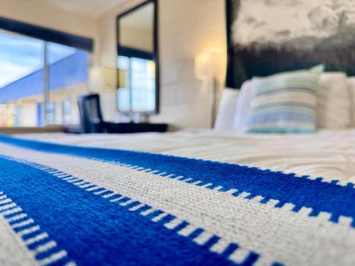 a bedroom with a bed with a blue rug on it at Relax Inn At Ashland in Ashland